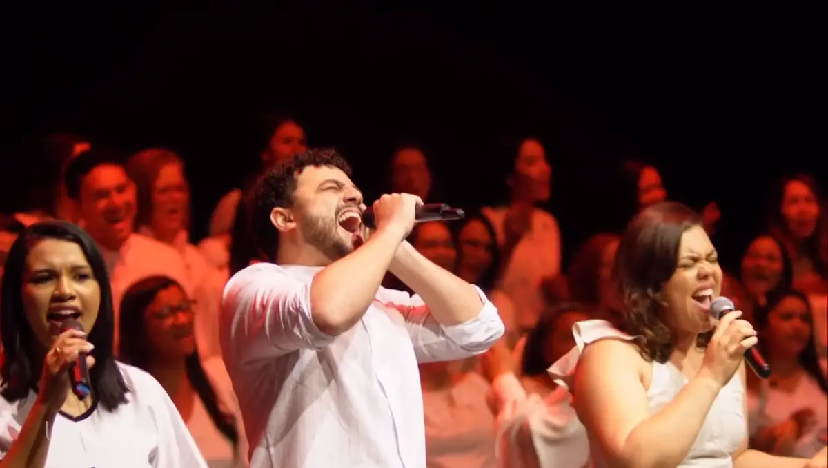 Solistas do coral cantando com emoção ao microfone